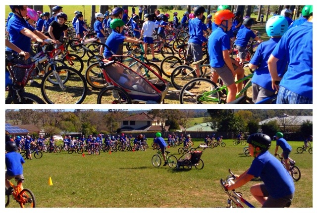 Top pic kids on bikes, vibrant colours, bike helmets, bright blue school uniforms prevail, Mac in his jogger in the midst of it all.  bottom pic kids in the distance, Mac and his mate riding up to meet the crowd.