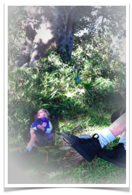 A shot of Mac sitting in the distance in front of our giant Moreton Bay Fig tree in our garden, dappled light coming through, school uniform, black converse high tops.  Blended into the corner of the pic is a close up of his shoes and the small sunsprite device attached to his shoelaces on his left foot.